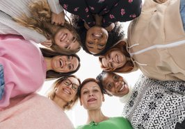 Mehrere Frauen stehen im Kreis und schauen nach unten in die Kamera. Foto: Freepik