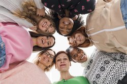 Mehrere Frauen stehen im Kreis und schauen nach unten in die Kamera. Foto: Freepik