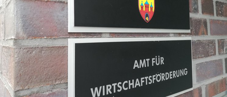 Zwei Schilder im Eingangsbereich der Wirtschaftsförderung Oldenburg: Stadt Oldenburg (mit Wappen), Amt für Wirtschaftsförderung. Foto: Stadt Oldenburg
