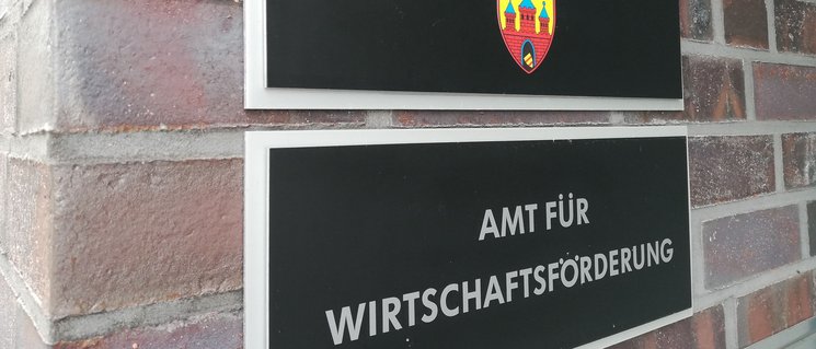 Zwei Schilder im Eingangsbereich der Wirtschaftsförderung Oldenburg: Stadt Oldenburg (mit Wappen), Amt für Wirtschaftsförderung. Foto: Stadt Oldenburg