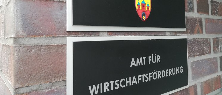 Zwei Schilder im Eingangsbereich der Wirtschaftsförderung Oldenburg: Stadt Oldenburg (mit Wappen), Amt für Wirtschaftsförderung. Foto: Stadt Oldenburg