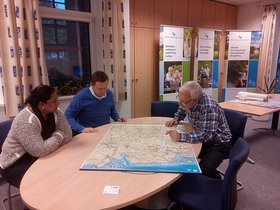 Darby Gounden, Mark Westerberg (beide Buffalo City) und Egon Harms (OOWV) betrachten eine Karte Norddeutschlands. Foto: Stadt Oldenburg