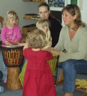 Eine männliche und eine weibliche Lehrkraft mit drei Kindern musizieren mit Djemben. Foto: Stadt Oldenburg