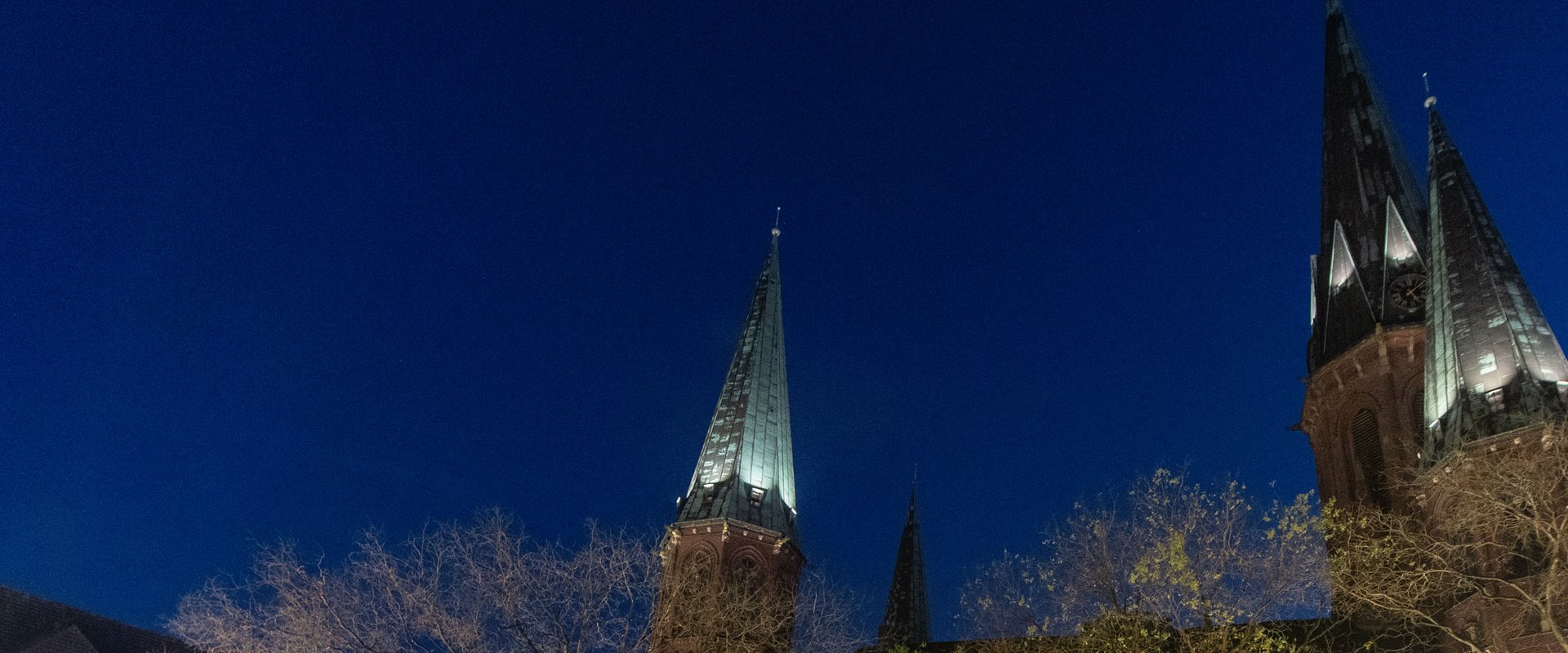 Drei Türme der Lamberti-Kirche sind beleuchtet. Foto: Sascha Stüber