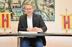Ministerpräsident Daniel Günther trägt sich ins Goldene Buch ein. Foto: Sascha Stüber