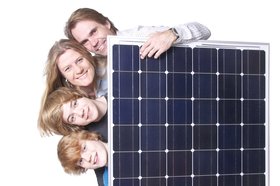 Familie hinter Solarmodul. Foto: fotolia.com/grafikplusfoto