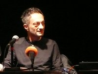 Feridun Zaimoglu sitzt vor einem Mikrofon. Foto: Literaturhaus Oldenburg