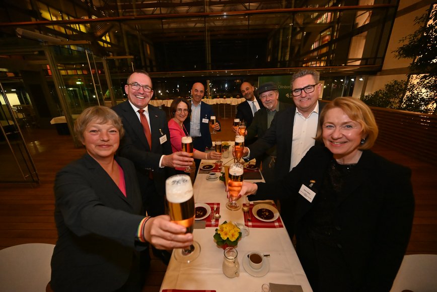 Geladene Gäste an einer langen Tafel. Foto: Torsten von Reeken