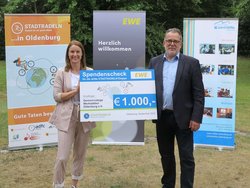 Vera Weidemann, Vorständin Personal und Recht EWE Aktiengesellschaft, überreicht den Scheck für das Erreichen des Etappenziels an Gerhard Wessels, Vorstand Gemeinnützige Werkstätten Oldenburg e.V. Foto: Stadt Oldenburg