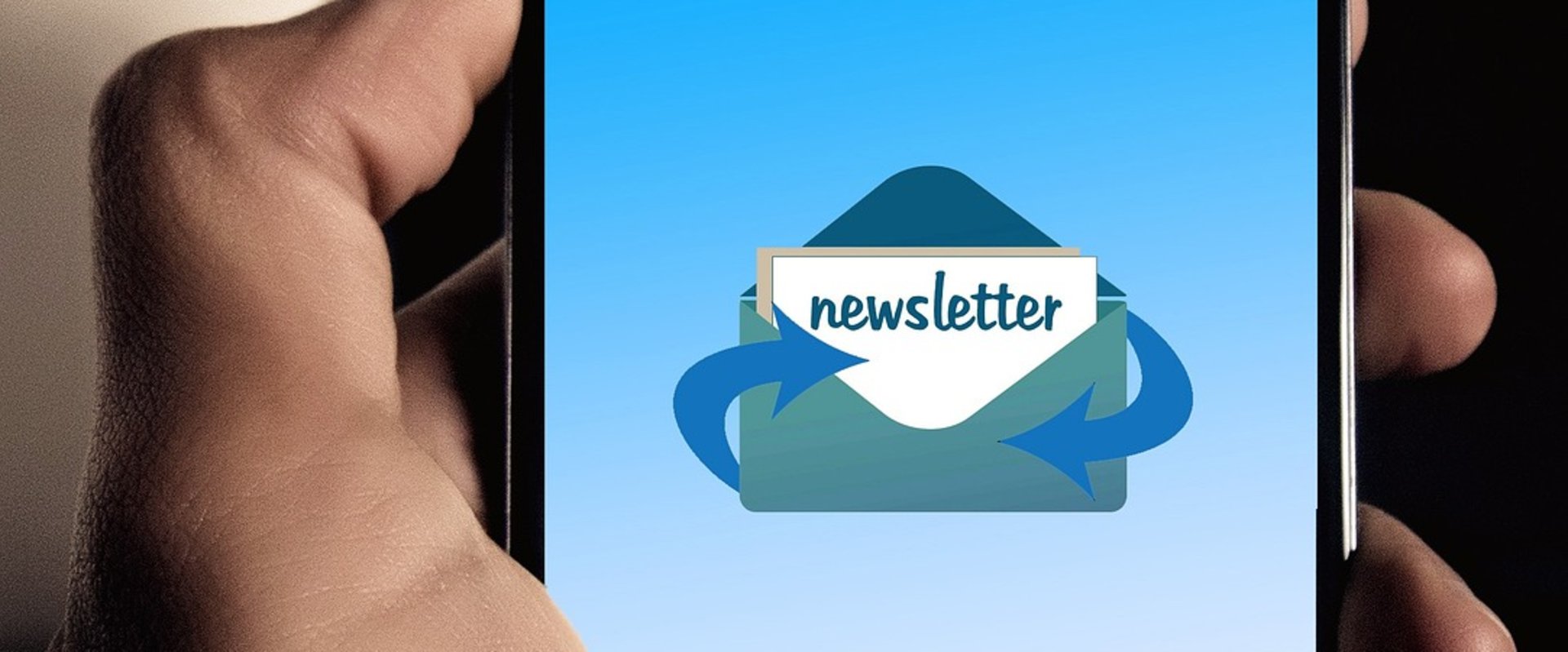 Linke Hand hält Smartphone mit Symbol für Newsletter: geöffneter Briefumschlag mit Dokument mit Aufschrift „Newsletter“ sowie Pfeilen zur Verdeutlichung von Ein- und Ausgang. Foto: Gerd Altmann/Pixabay