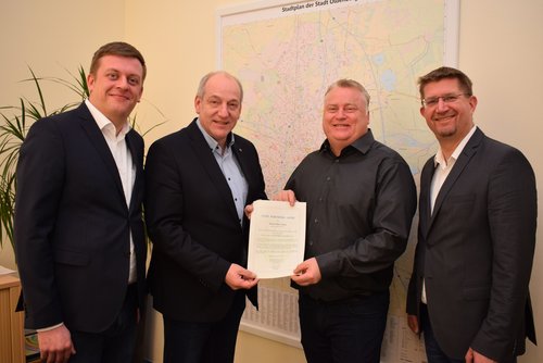 Dennis Mewis-Amme (Dritter von links) betreut weiterhin den Kehrbezirk Alexandersfeld/Alexanderstraße. Zu seiner erneuten Bestellung gratulierten (von links) Michael Deeken, Michael Lorenz und Christian Aster. Foto: Stadt Oldenburg