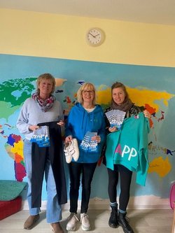 Meike Plewa (StoP), Marianne (Aktive bei StoP) und Laura Leonhardt (StoP) halten Klamotten von der Spende für das Frauenhaus in Oldenburg und Flyer von StoP