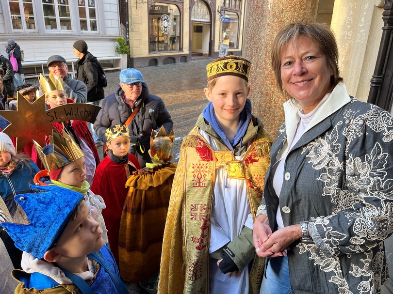 Bürgermeisterin Christine Wolff (rechts) begrüßte die Sternsingerkinder und ihre Begleitpersonen vor dem Alten Rathaus, nachdem sie den Segensspruch „C+M+B“ mit Kreide an die Wand gebracht hatten. Foto: Stadt Oldenburg