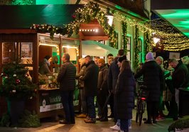 Menschen stehen an der Holzhütte für Grünkohleintopf an. Foto: OTM/Henricus Lüschen