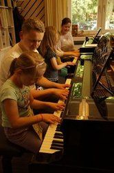 Zwei Lehrkräfte spielen mit zwei Schülern an Klavieren. Foto: Anne Hoeltzenbein Untterricht amZwei Lehrkräfte spielen mit zwei Schülern an Klavieren. Foto: Anne Hoeltzenbein Klavier. Foto: Anne Hoeltzenbein