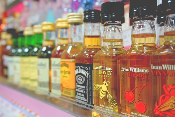 Unterschiedliche Alkoholflaschen in einem Regal. Foto: tookapic/Pixabay