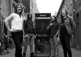 Die Band Splinter steht auf einer Straße vor einem Verstärker. Bild: Splinter