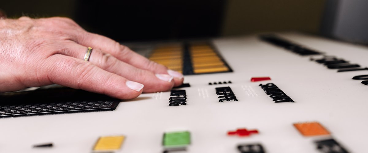Hand über einem Schild mit Brailleschrift. Foto: Izabela Mittwollen 