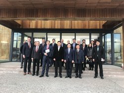 Sino-German Ecopark, Neben OB Krogman: Herr Dr. Tieyi Zhu, Neuer Präsident vom SGEP. Foto: Stadt Oldenburg Die Oldenburger Delegation steht mit Vertreterinnen und Vertretern des Sino-German Ecopark vor einer Gebäudefassade aus Holz und Glas. Foto: Stadt Oldenburg