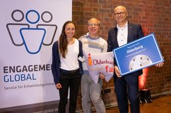 Jannika Mumme und Frank Hinrichs aus der Stadtverwaltung nahmen den Preis für Oldenburg gemeinsam mit Jörg Meier (Mitte) vom Aktionsbündnis „Oldenburg handelt fair“ entgegen. Foto: Astrid Piethan/Kommune bewegt Welt Jannika Mumme und Frank Hinrichs aus der Stadtverwaltung nahmen den Preis für Oldenburg gemeinsam mit Jörg Meier (Mitte) vom Aktionsbündnis „Oldenburg handelt fair“ entgegen. Foto: Astrid Piethan/Kommune bewegt Welt