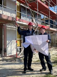 Zwei Kollegen der Feuerwehr mit einem Plan bei einer Ortsbesichtigung auf einer Baustelle. Foto: Stadt Oldenburg