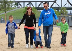Familie mit drei Kindern auf einem Spielplatz. Foto: Alexandra H./Pixelio