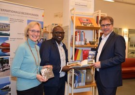 Samkelo Ngwenya übergab Bücher aus Oldenburgs südafrikanischer Partnerkommune Buffalo City Metro an Oberbürgermeister Jürgen Krogmann und Heike Janssen, Fachdienstleiterin Bibliotheken. Foto: Stadt Oldenburg