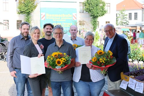Anerkennung für jahrzehntelanges Engagement auf den Wochenmärkten: (von links) Dennis Ostendorf, Dr. Julia Figura, Finn Brouwer-Gienapp, Peter Kluin, Wilfried Müller, Corinna Schubert und Michael Lorenz. Foto: Sascha Stüber Anerkennung für jahrzehntelanges Engagement auf den Wochenmärkten: (von links) Marktmeister Dennis Ostendorf, Marktdezernentin Dr. Julia Figura, Finn Brouwer-Gienapp (Vorstand Verein Oldenburger Marktkaufleute e.V.), Peter Kluin, Wilfried Müller, Corinna Schubert und Michael Lorenz (Leiter Bürger- und Ordnungsamt). Foto: Sascha Stüber