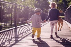 Zwei kleine Kinder von hinten auf einer Brücke. Foto: freestocks.org/Pexels.com