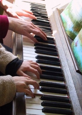 Kleine und große Hände gemeinsam am Klavier. Foto: Rainer Sturm/pixelio