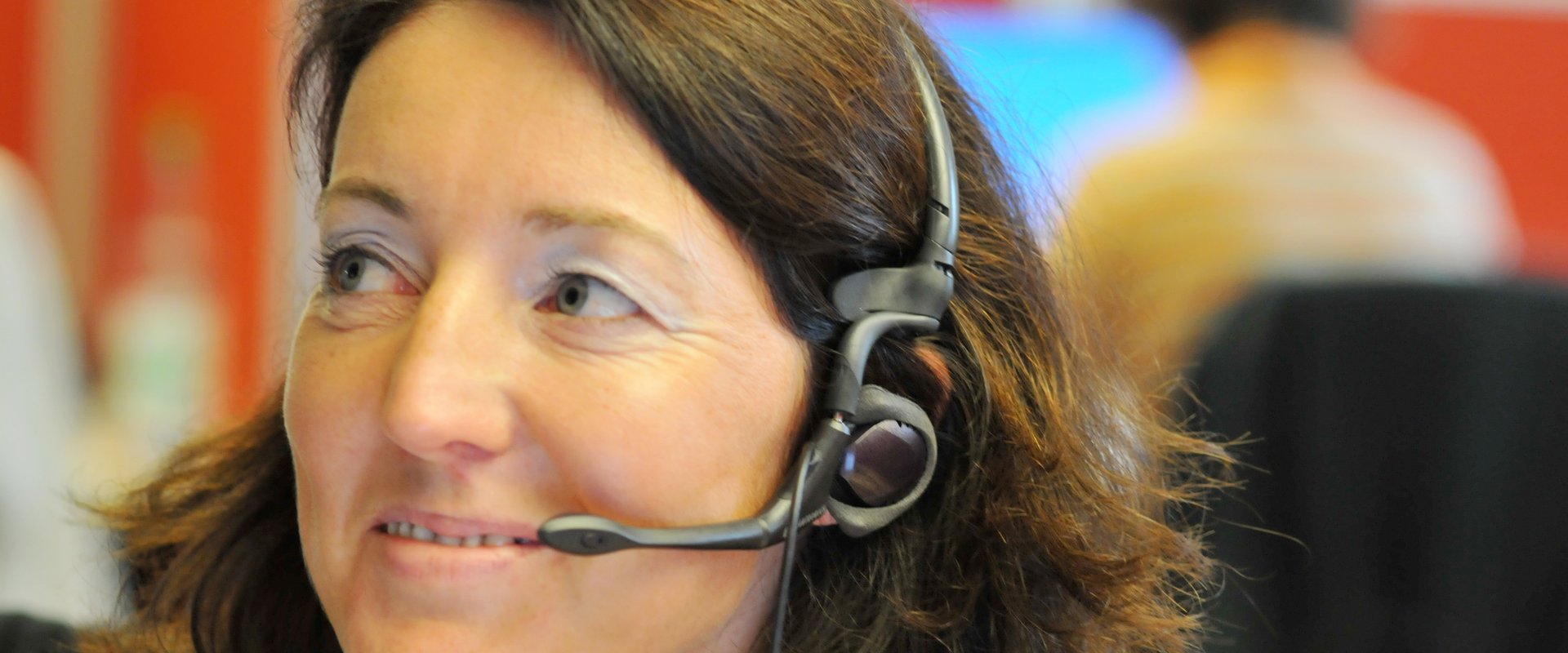 Eine Frau telefoniert im ServiceCenter mit einem Headset. Foto: Peter Duddek