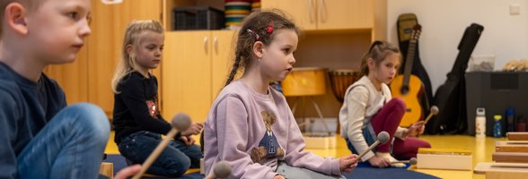 Musikalische Früherziehung, die Spaß macht und nebenbei wichtige Fähigkeiten fördert – aufmerksam folgen die Kinder der Lehrerin und spielen die Melodie auf Klangbausteinen nach. Foto: Sascha Stüber