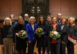 Preisträgerin Eva Kranenburg (Mitte mit Blumen) mit den Mitgliedern der Jury, der Leiterin des Kulturbüros Paula von Sydow (links), Bürgermeisterin Petra Averbeck (fünfte von links) sowie Laudator Vitali Konstantinov (vierter von links) und den weiteren Nominierten Heike Falkenberg (vierte von rechts) und Jenny Hungerbühler (dritte von links). Foto: Mohssen Assanimoghaddam