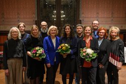 Preisträgerin Eva Kranenburg (Mitte mit Blumen) mit den Mitgliedern der Jury, der Leiterin des Kulturbüros Paula von Sydow (links), Bürgermeisterin Petra Averbeck (fünfte von links) sowie Laudator Vitali Konstantinov (vierter von links) und den weiteren Nominierten Heike Falkenberg (vierte von rechts) und Jenny Hungerbühler (dritte von links). Foto: Mohssen Assanimoghaddam
