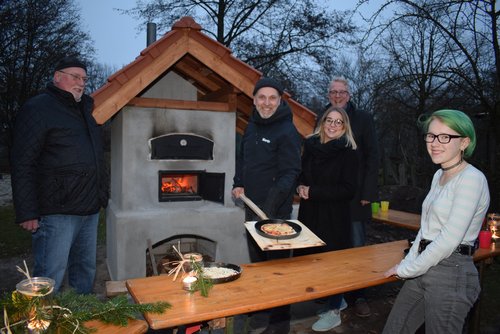 Freuten sich über die gelungene Ofen-Einweihung: (von links) Eckhardt Schwenker, Martin Haff, Alina Bremke und  Christian Fritsch – eine der ersten Pizzen ließ sich Abenteuerspielplatz-Besucherin Lia schmecken. Foto: Stadt Oldenburg