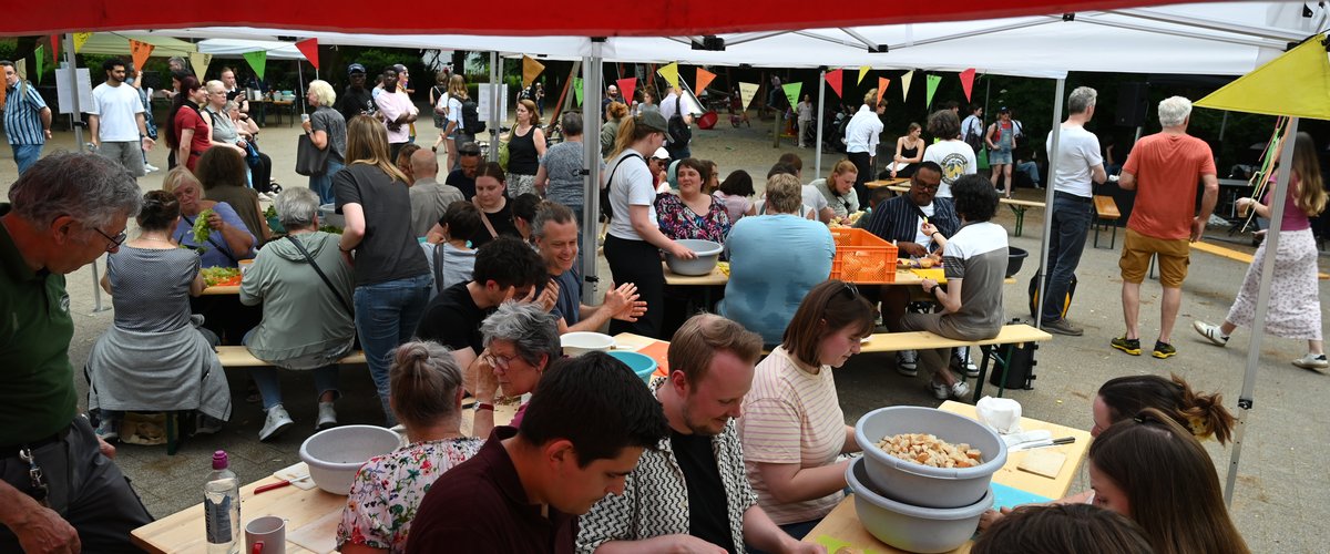 Zu sehen sind viele Menschen, die gemeinsam bei der diesjährigen Schnippeldisko in Bloherfelde gerettete Lebensmittel zu leckeren Gerichten verarbeiten. Foto: Jörg Hemmen