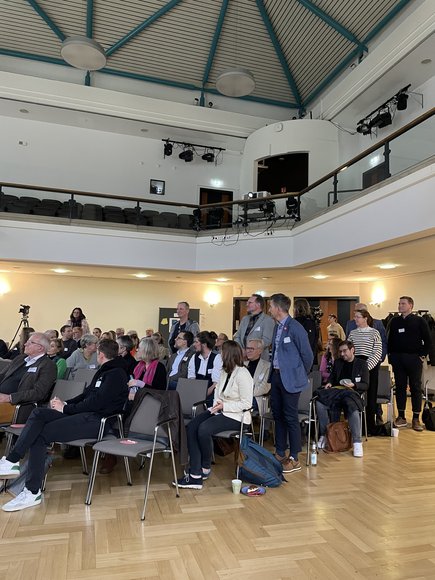 Bei der Publikumsabfrage stehen Vertreterinnen und Vertreter aus Produktionsunternehmen auf. Foto: Stadt Oldenburg