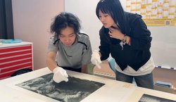 Behutsam mit weißen Handschuhen betrachten Zhenpeng Zhang (links) und Jianing Wang einen Original-Druck von Horst Janssen. Foto: Stadt Oldenburg Behutsam mit weißen Handschuhen betrachten Zhenpeng Zhang (links) und Jianing Wang einen Original-Druck von Horst Janssen. Foto: Stadt Oldenburg