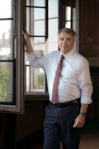 Oberbürgermeister Jürgen Krogmann stehend am Fenster im Hemd.