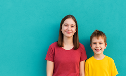 Ein Mädchen und ein Junge vor türkisem Hintergrund. Bild: generiert mit ChatGPT