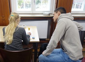Bundesfreiwilliger Simon Dohrs (rechts) unterstützt ein Mädchen beim Geschichten schreiben. Foto: Stadt Oldenburg