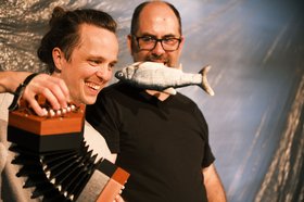 Szenenbild „Tisch und Fisch“ mit Akkordeon und Fisch. Foto: Patrick Zenner