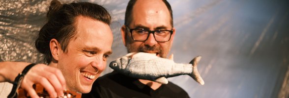 Szenenbild „Tisch und Fisch“ mit Akkordeon und Fisch. Foto: Patrick Zenner