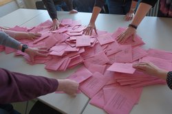 Stimmzettel der Bundestagswahl 2025 liegen auf einem Tisch und werden ausgezählt. Foto: Sascha Stüber