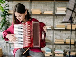Mädchen spielt Akkordeon. Foto: Pexels
