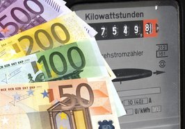 Energiesparen: Im Hintergrund ein Stromzähler, im Vordergrund gefächerte Geldscheine. Foto: Thorben Wengert/Pixelio.de