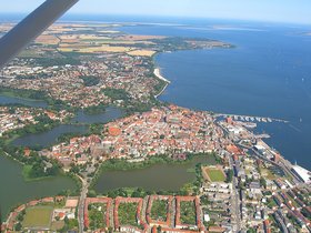 Blick auf Stralsund aus der Luft, eine Stadt am Wasser und mit Seen im Stadtgebiet. Foto: Viktoria Hillmann