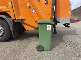 Mülltonne mit Barcodeaufkleber vor einem Müllwagen. Foto: Stadt Oldenburg