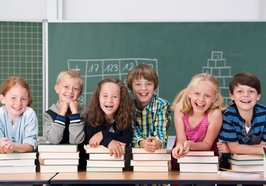Kinder mit Büchern vor einer Tafel. Foto: contrastwerkstatt/Fotolia