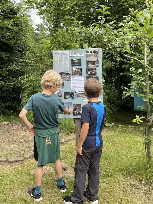 Zwei Jungen schauen sich Fotos aus den Jahren 1987 bis 1989 an, die mit vielen anderen Fotos im Zaubergarten ausgestellt waren. Foto: Stadt Oldenburg